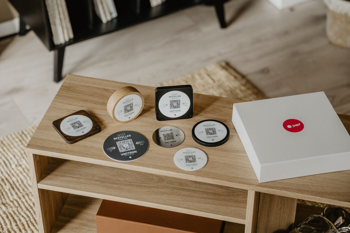 Open SMOOF sample box with four wooden BASES and three DOTs in gloss, matte, and stainless steel.